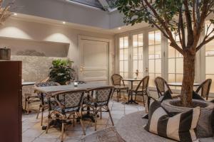 a room with tables and chairs and a tree at Home Hotel Bastion in Oslo