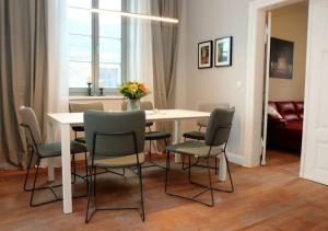 a dining room table with chairs and a white table and a room at 6-Personen-Fewo in Buchholz