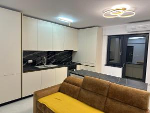 a living room with a couch and a kitchen at Apartament Magnolia Panoramic in Craiova +3 photos