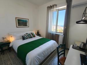 a bedroom with a bed with a green and white blanket at Villa Cristina in Casteldaccia