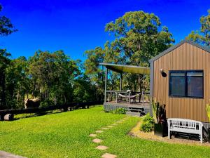 a house with a bench in a yard at El Rancho Cabarita Beach - Highlander in Clothiers Creek