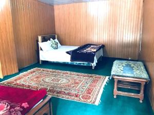 a room with a bed and a table and a rug at Rama lake view Hotel in Astor