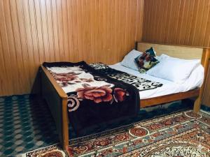a small bed in a small room with a sqor sqor at Rama lake view Hotel in Astor +3 photos