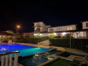a swimming pool in front of a house at night at Hotel Campestre Jardín Cafetero - Quindio in Armenia