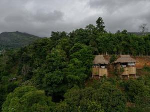 an aerial view of a forest with huts on a hill at Wanna’s house in Ban Huai Khai