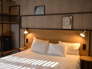 a bedroom with a large bed with white pillows at ibis Chateauroux in Châteauroux +121 photos