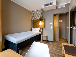a small room with a bed and a table at ibis Mainz City in Mainz +88 photos
