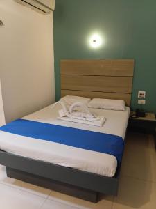 a bedroom with a bed with a blue and white blanket at Nice Hotel in Manila
