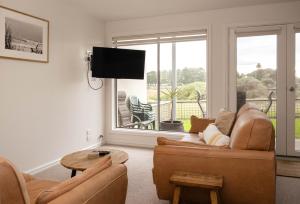 a living room with a couch and a tv at Moyne Views 2 in Port Fairy