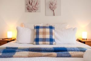 a bed with blue and white pillows and two lamps at Moyne Views 2 in Port Fairy