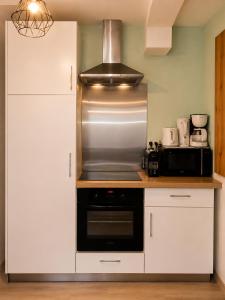 a kitchen with a stove and a microwave at Duplex Le Doux Rêve in Dole +5 photos