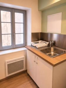 an empty kitchen with a sink and a sink at Duplex Le Doux Rêve in Dole