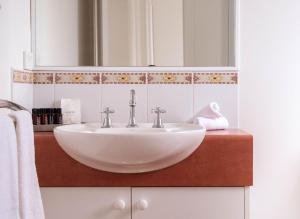 a bathroom with a white sink and a mirror at Moyne Views 2 in Port Fairy +27 photos