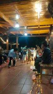 a group of children sitting in a room with lights at Nhà Gỗ Cạnh Suối in Bản Det
