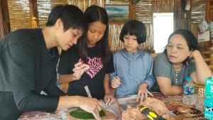a group of people standing around a table at Nhà Gỗ Cạnh Suối in Bản Det