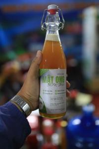 a person holding a bottle ofmt one soda at Nhà Gỗ Cạnh Suối in Bản Det