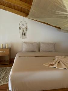 a bedroom with a white bed with a clock on the wall at Tiny house with amazing view in Arusha