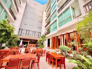 a restaurant with wooden tables and chairs in front of a building at Sabaidee@Lao Hotel Vientiane in Vientiane