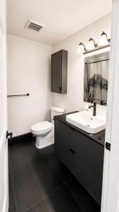 a bathroom with a white toilet and a sink at Mountain Views - Ocean Glimpses - Near Victoria - 2BR suite in Sooke