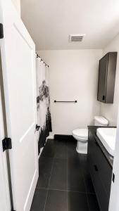 a white bathroom with a toilet and a sink at Mountain Views - Ocean Glimpses - Near Victoria - 2BR suite in Sooke