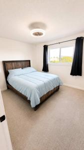 a bedroom with a large bed and a window at Mountain Views - Ocean Glimpses - Near Victoria - 2BR suite in Sooke
