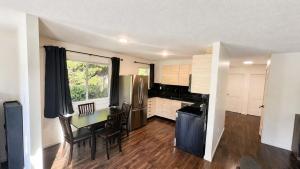 a kitchen with a table and a dining room at Mountain Views - Ocean Glimpses - Near Victoria - 2BR suite in Sooke