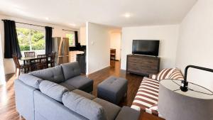 a living room with a couch and a tv at Mountain Views - Ocean Glimpses - Near Victoria - 2BR suite in Sooke +3 photos