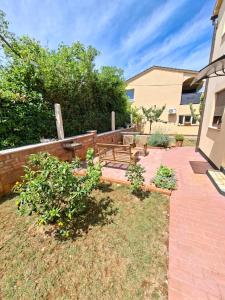 a patio with two benches in a yard at Studio apartman SAN 3 in Ližnjan +4 photos