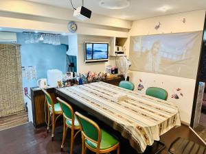 a room with a table and chairs and a large screen at 自遊人の宿 in Odawara