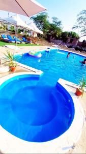 a large blue swimming pool with people in it at Edelmon't Beach in Los Órganos