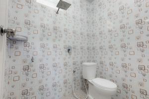 a bathroom with a toilet and a lot of pictures on the wall at Emerald Cabin House in Kejajar