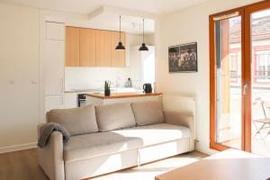 a living room with a couch and a kitchen at Large apartment with balcony - Stade de France in Saint-Denis