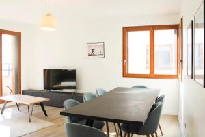 a dining room with a table and chairs and a tv at Large apartment with balcony - Stade de France in Saint-Denis