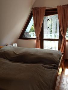a bed sitting in a bedroom with a window at Ferienhaus mit Pool am See in Malchow