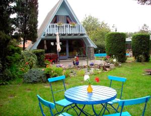 a table and chairs in a yard with a house at Ferienhaus mit Pool am See in Malchow