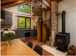 a kitchen with a wooden table with a wood stove at Chalet-Širava in Vinné