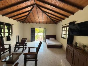 a bedroom with a bed and a tv in a room at Hotel Campestre Jardín Cafetero - Quindio in Armenia +33 photos