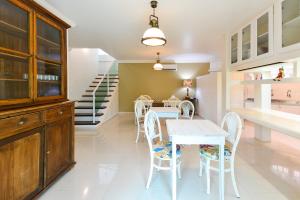 a dining room with a table and chairs and a staircase at Louise village in Juquei