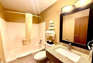 a bathroom with a sink and a toilet and a mirror at Super 8 by Wyndham Melrose in Melrose