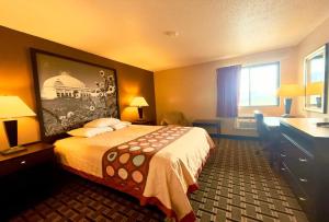 a hotel room with a bed and a desk at Super 8 by Wyndham Melrose in Melrose