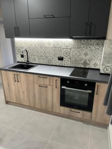 a kitchen with a sink and a stove at Комплекс Траките in Bŭnzareto
