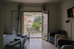 a bedroom with a bed and a sliding glass door with a balcony at Karamelaki in Pythagoreio