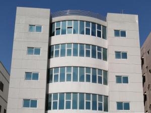 a tall white building with many windows at Alsayah in Jazīrat as Sāyah
