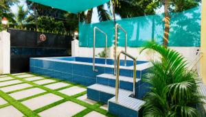 a swimming pool with blue tiles and stairs at Eden Cozy Villa in Virāmpattinam