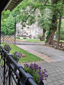 a park with a bench with purple flowers on it at Moravski konak- Moravian Inn in Ovčar Banja