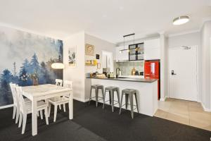 a kitchen and dining room with a table and chairs at OPTUS Stadium 2BR CBD Apartment with FREE Parking in Perth