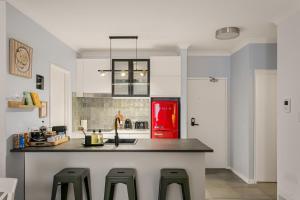 a kitchen with a counter and a red refrigerator at OPTUS Stadium 2BR CBD Apartment with FREE Parking in Perth +16 photos