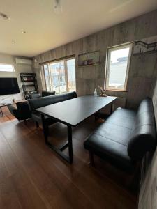 a living room with a table and a couch at Hotel Ji ホテル時 in Furano +9 photos