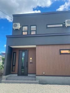 a black house with a brown at Hotel Ji ホテル時 in Furano