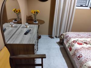 a bedroom with a bed and a desk with flowers at Bee happy in Agioi Apostoli